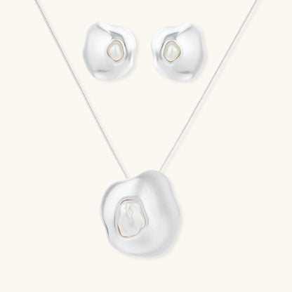 Organic curved earrings and necklace featuring baroque pearls in eco-zinc alloy settings on neutral background