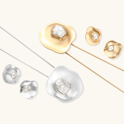 Organic curved earrings and necklace featuring baroque pearls in eco-zinc alloy settings on neutral background