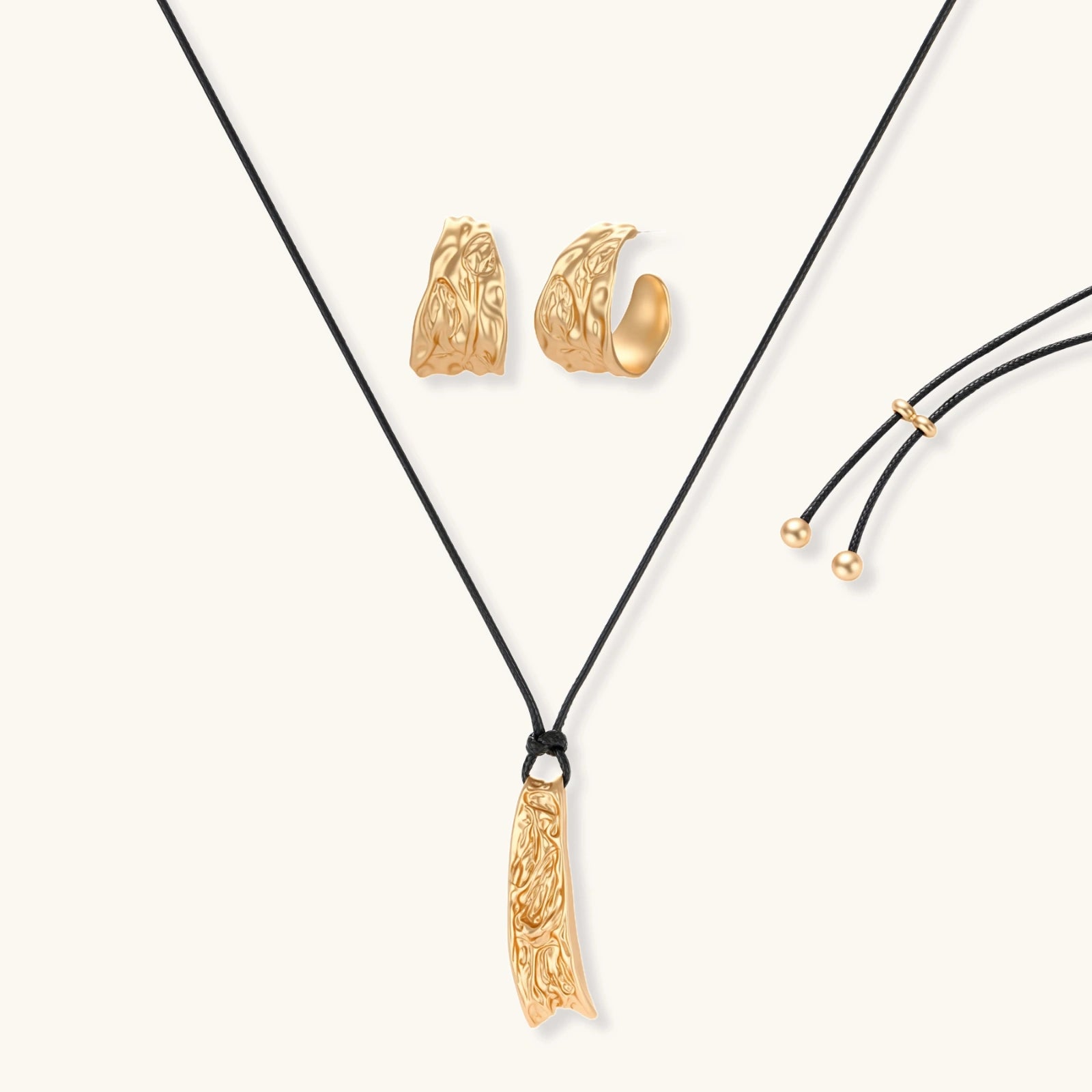 Gold-toned textured pendant necklace with matching hoop earrings featuring organic flowing patterns on white background.