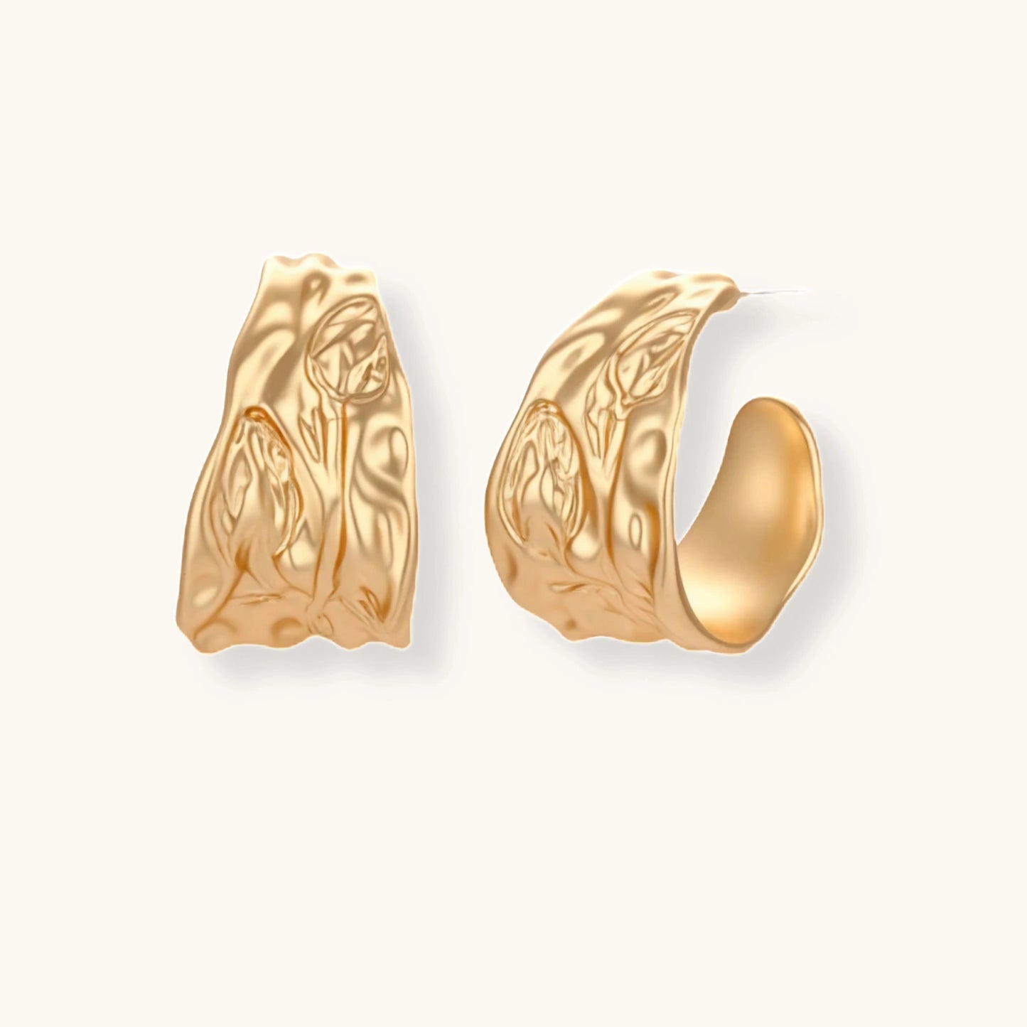 Gold-toned textured pendant necklace with matching hoop earrings featuring organic flowing patterns on white background.
