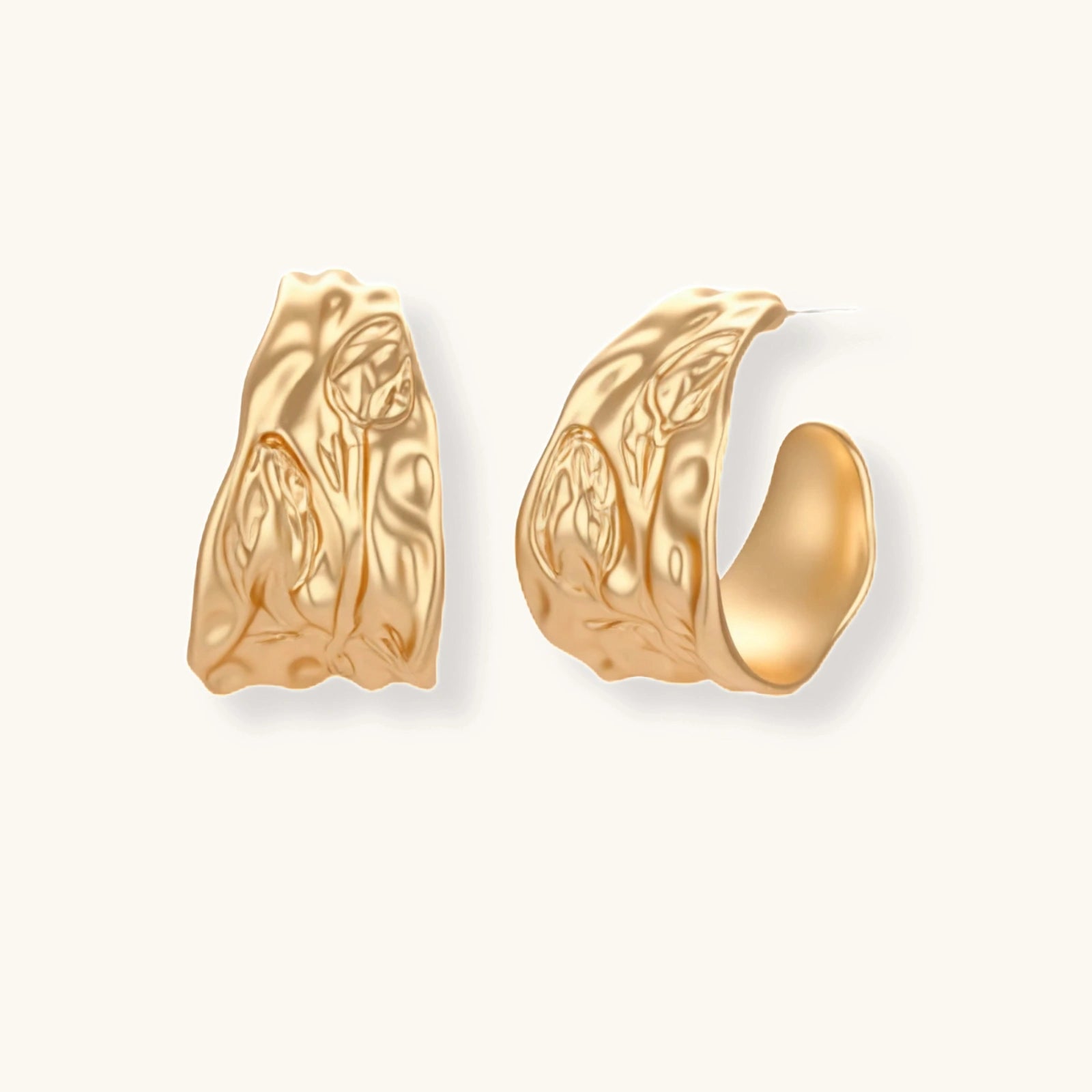 Gold-toned textured pendant necklace with matching hoop earrings featuring organic flowing patterns on white background.