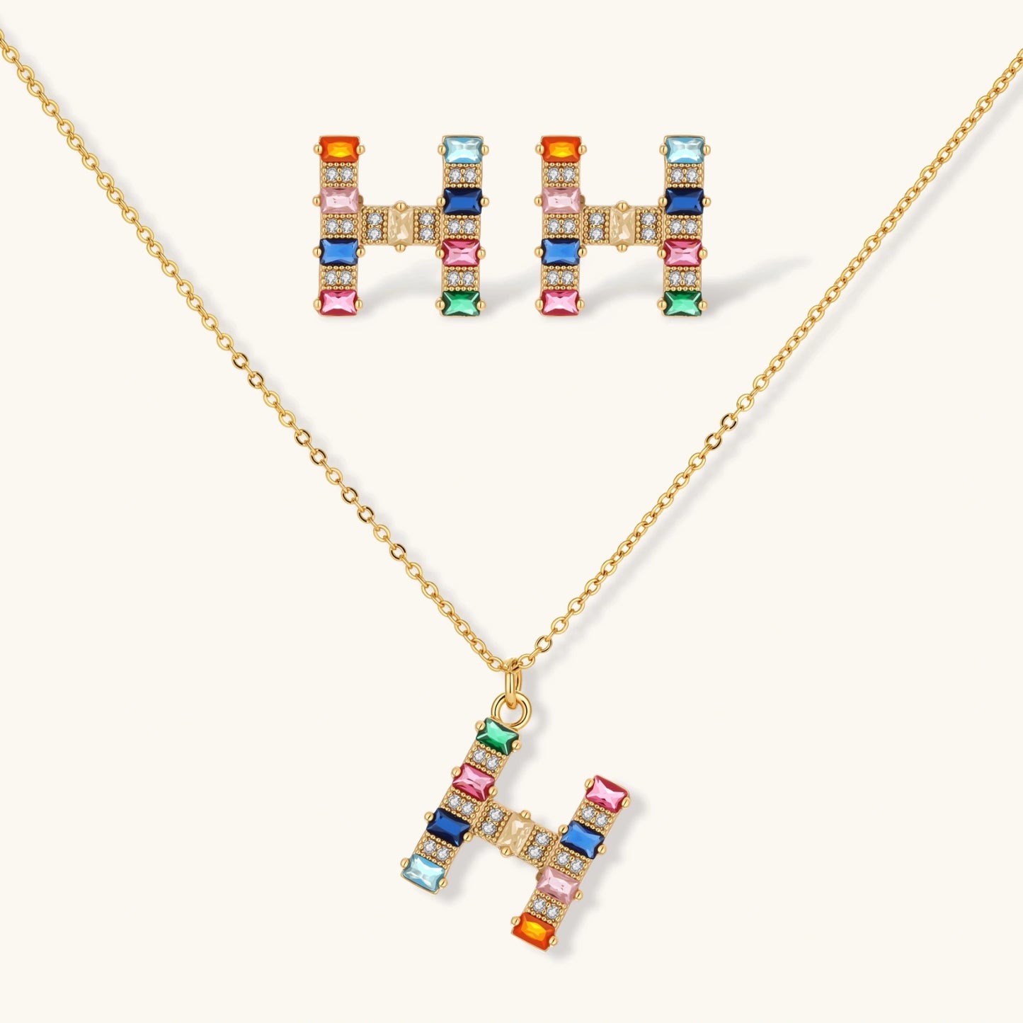 Gold-plated letter H jewelry set with multicolor zirconia stones in emerald cuts, showing necklace pendant and matching earrings