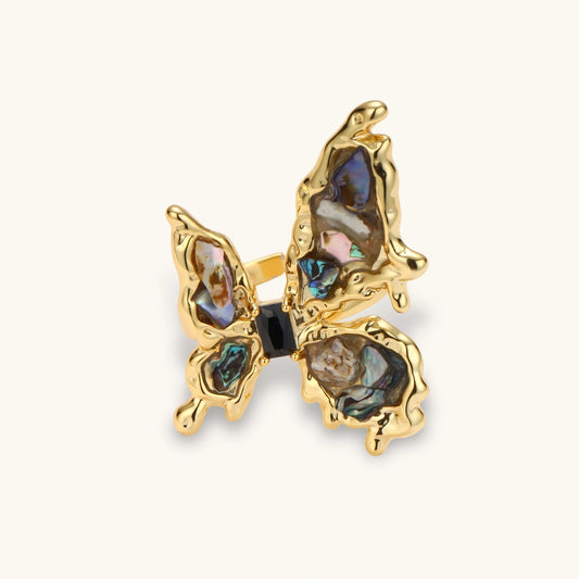 Gold-plated adjustable ring featuring iridescent shell pieces in purple, blue and green tones arranged in butterfly formation