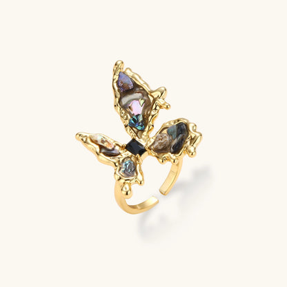 Gold-plated adjustable ring featuring iridescent shell pieces in purple, blue and green tones arranged in butterfly formation